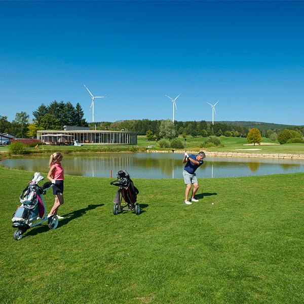 Zwei Leute am Golf spielen vor See - Golfpark Bostalsee